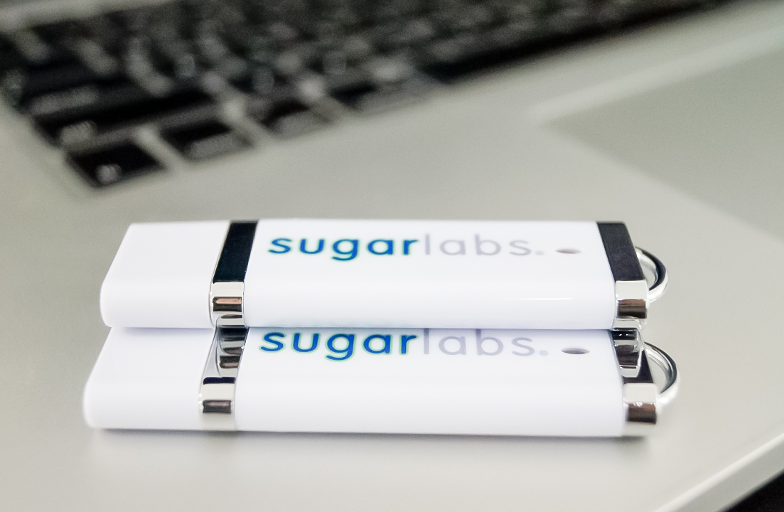 Two USB drives on a laptop. The Sugar Labs logo is prominent, and
the drives are shiny.